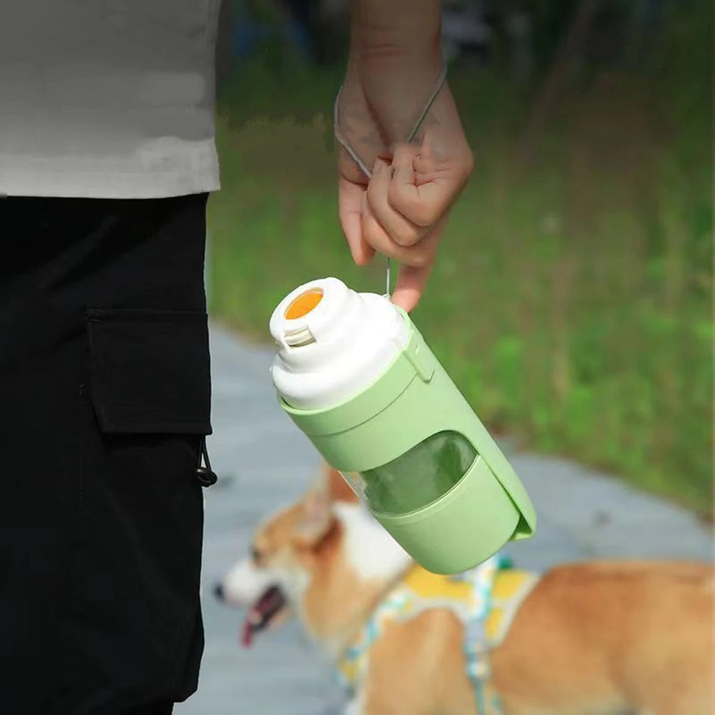 Person walking a corgi while carrying a green portable pet water bottle